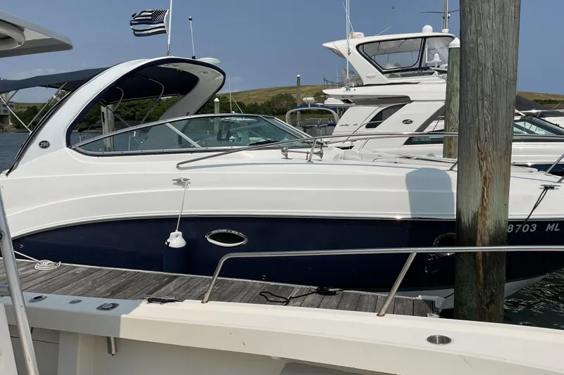 Slide: The Image of 2013 Rinker 290 Express Cruiser docked at marina, side view. - 2