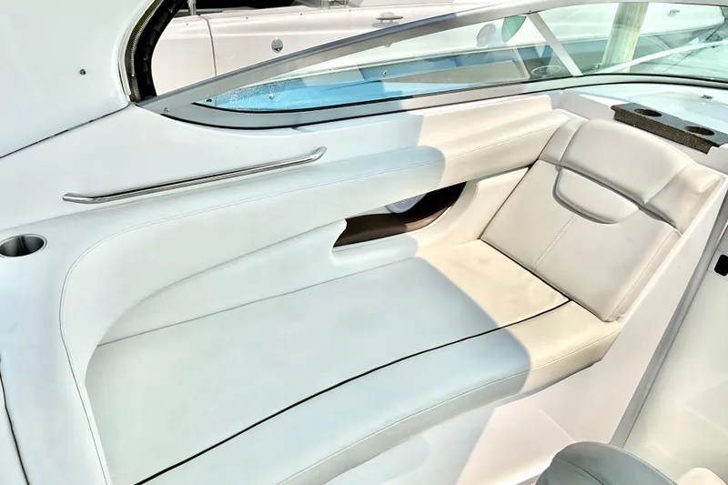 Slide: The Image of 2013 Rinker 290 Express Cruiser interior seating with white upholstery and sleek design. - 7
