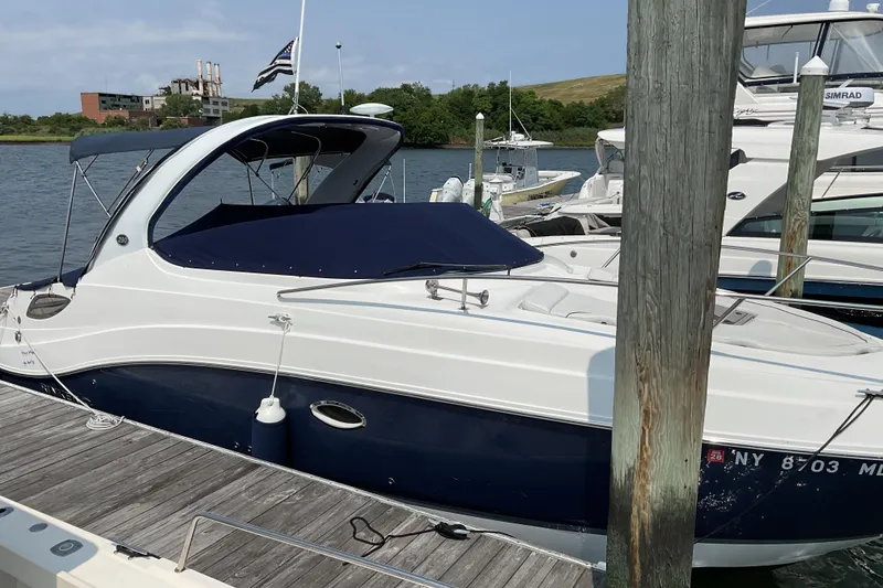 Slide: The Image of 2013 Rinker 290 Express Cruiser docked at marina, covered and ready for use. - 9
