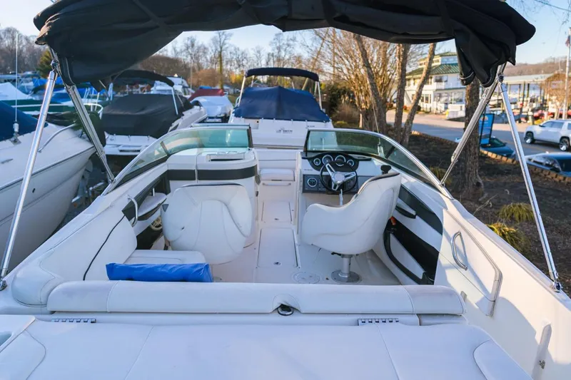 Slide: The Image of 2015 Sea Ray 220 Sundeck boat interior with white seating and steering console. - 6