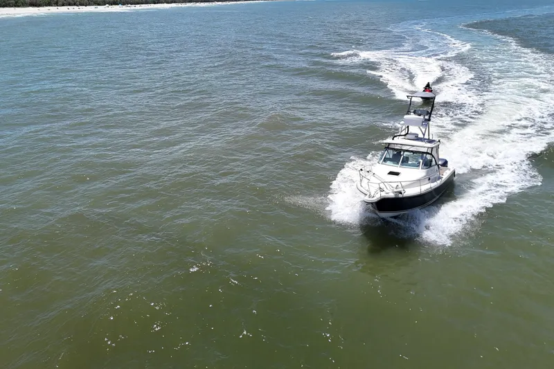 Slide: The Image of 2007 Pursuit OS 285 Offshore boat cruising on open water. - 11