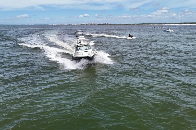 Slide: The Image of 2007 Pursuit OS 285 Offshore boat cruising on open water with clear skies. - 13