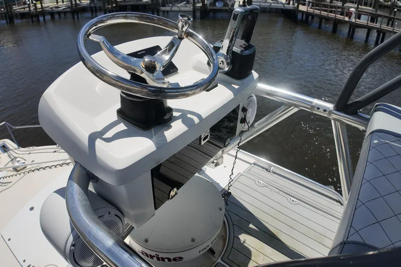 Slide: The Image of 2007 Pursuit OS 285 Offshore boat helm with steering wheel and controls, dockside view. - 15