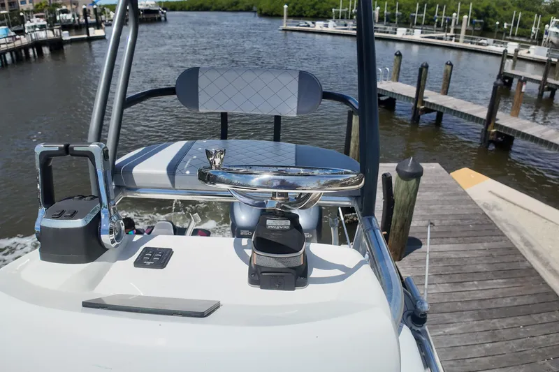 Slide: The Image of 2007 Pursuit OS 285 Offshore boat helm with controls, docked by a marina. - 16