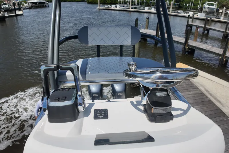 Slide: The Image of 2007 Pursuit OS 285 Offshore boat helm with controls and steering wheel, docked by the water. - 17