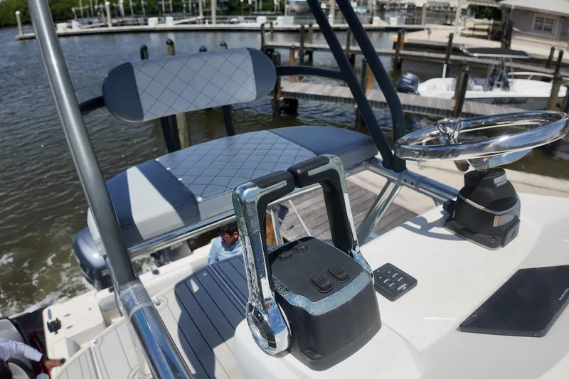 Slide: The Image of 2007 Pursuit OS 285 Offshore boat helm with steering wheel and controls at marina. - 18