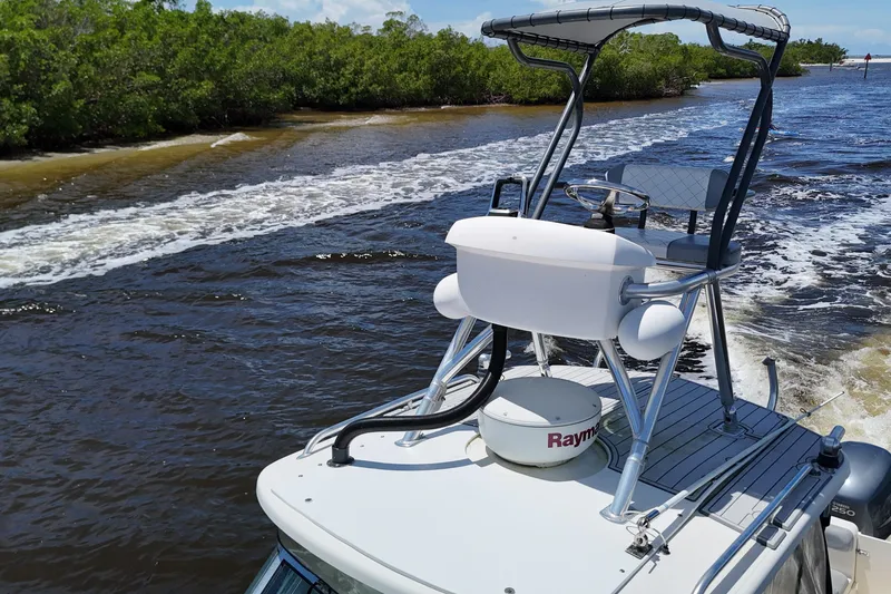 Slide: The Image of 2007 Pursuit OS 285 Offshore boat navigating through scenic waterway with lush greenery. - 20