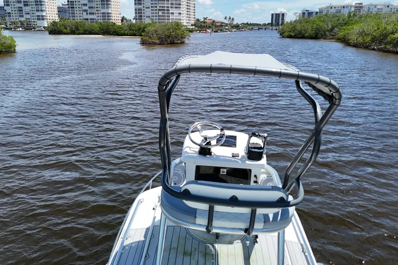 Slide: The Image of 2007 Pursuit OS 285 Offshore boat navigating a scenic waterway with buildings in the background. - 21