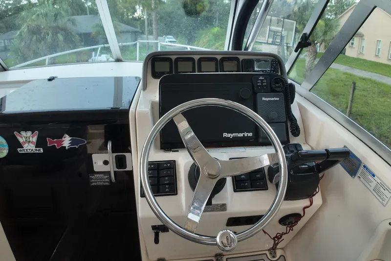 Slide: The Image of Helm of 2007 Pursuit 285 Offshore boat with Raymarine electronics and steering wheel. - 22