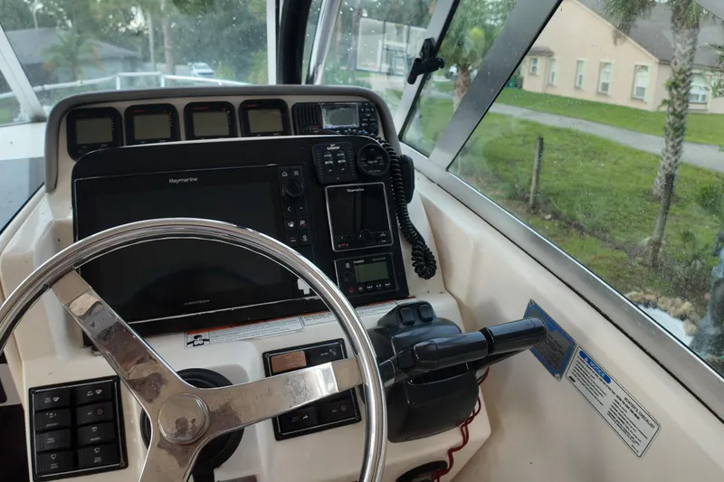 Slide: The Image of 2007 Pursuit 285 Offshore boat cockpit with steering wheel and navigation equipment. - 23