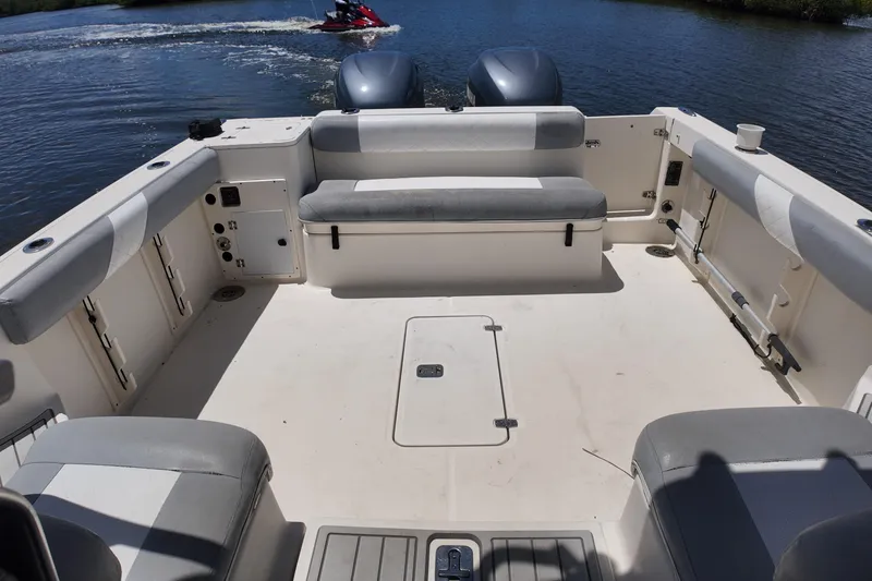 Slide: The Image of 2007 Pursuit OS 285 Offshore boat interior with seating, open deck, and watercraft in background. - 24