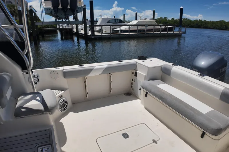 Slide: The Image of 2007 Pursuit OS 285 Offshore boat interior at marina, featuring seating and Yamaha engine. - 25