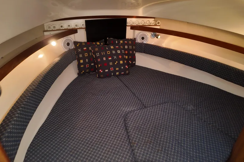 Slide: The Image of 2007 Pursuit 285 Offshore cabin interior with patterned cushions and ambient lighting. - 32