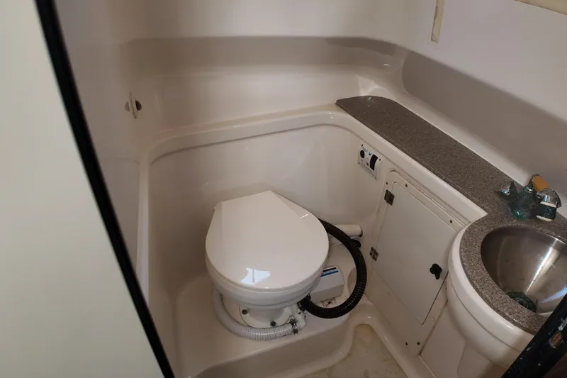 Slide: The Image of 2007 Pursuit 285 Offshore boat bathroom with toilet, sink, and storage cabinet. - 35