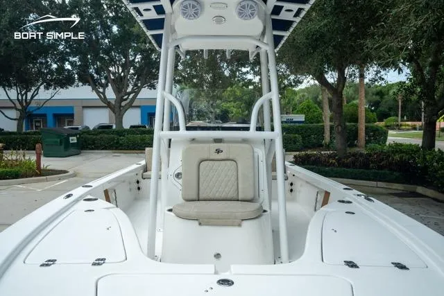 Slide: The Image of 2024 Sea Pro 208 Bay boat interior with seating and console, parked outdoors. - 16