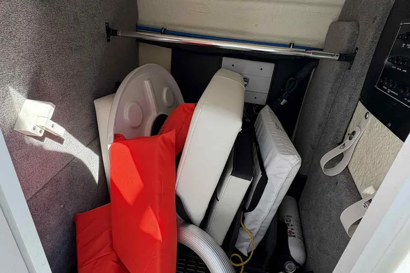 Slide: The Image of 2018 Monterey M65 boat interior with white and black seating, open windshield, and cup holders. - 19