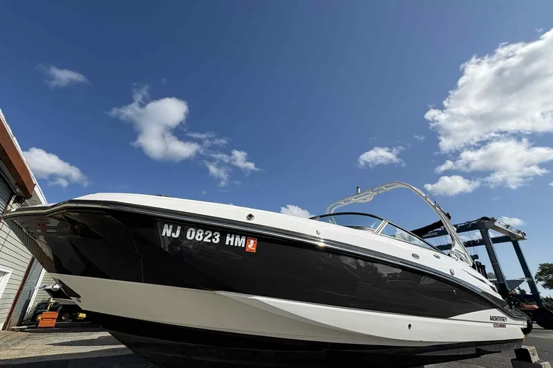 Slide: The Image of Front view of a 2018 Monterey M65 boat under a clear blue sky. - 2