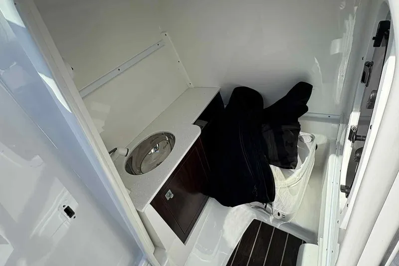 Slide: The Image of 2018 Monterey M65 boat with sleek white design and black canopy, docked outdoors. - 22