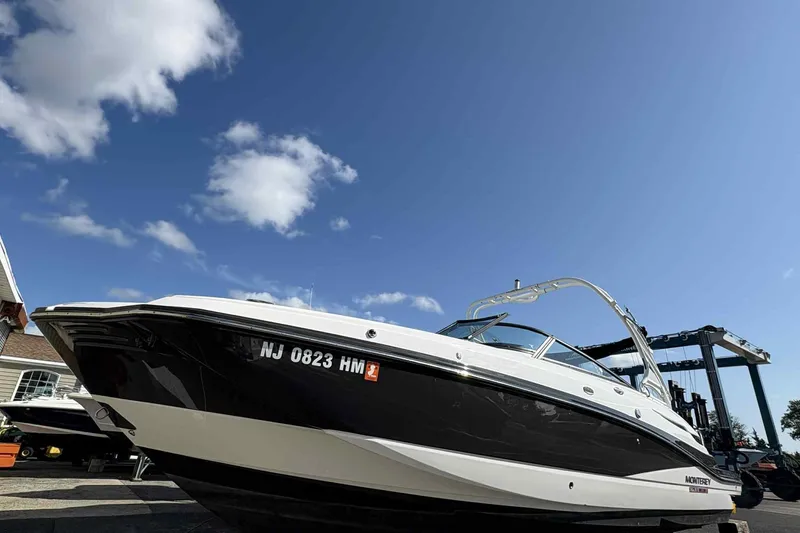 Slide: The Image of White Monterey M65 2018 boat with Verado engine, parked outdoors under blue sky. - 26