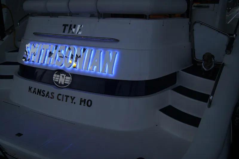 Slide: The Image of 1999 Neptunus 54 Hardtop Express yacht with illuminated name "Smithsonian," docked in Kansas City, MO. - 13