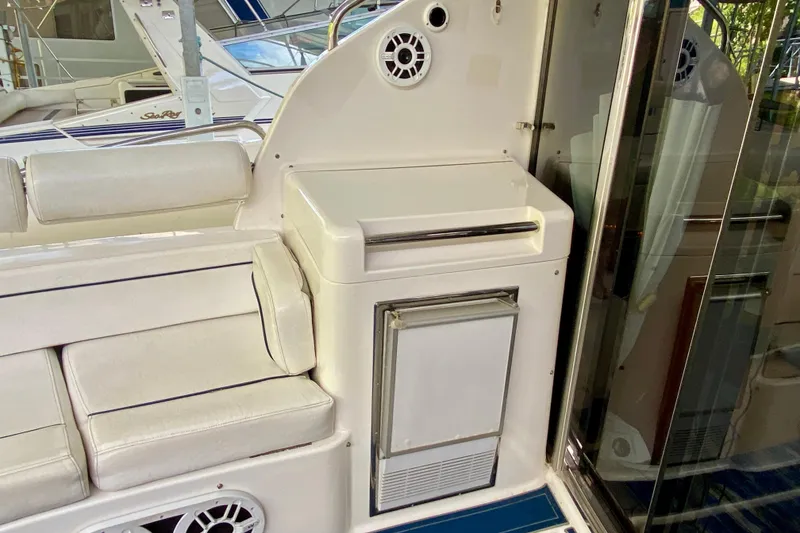 Slide: The Image of 1999 Neptunus 54 Hardtop Express yacht interior with white seating and built-in storage. - 16