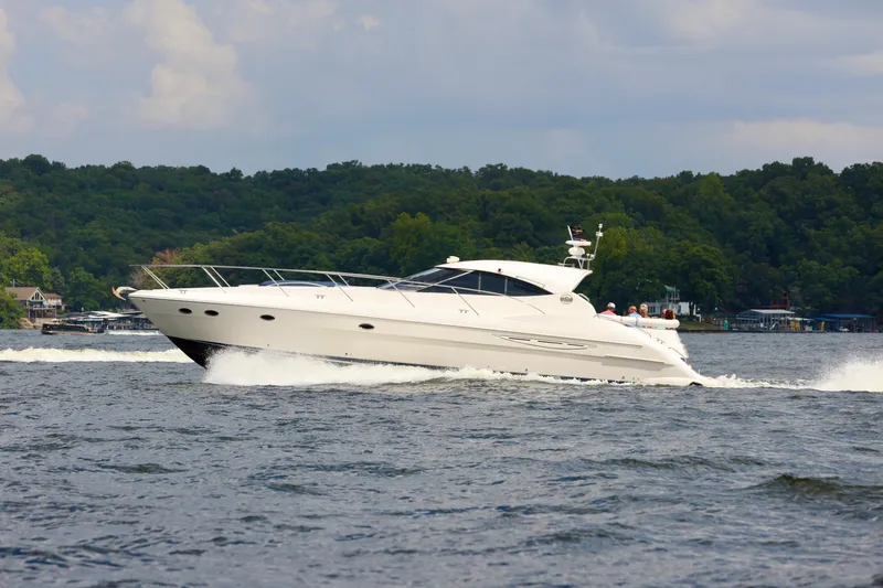 Slide: The Image of 1999 Neptunus 54 Hardtop Express yacht cruising on a scenic lake. - 2