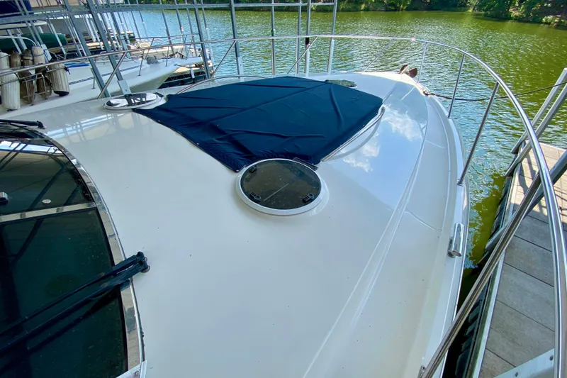 Slide: The Image of 1999 Neptunus 54 Hardtop Express yacht deck with blue cover, docked by the water. - 20