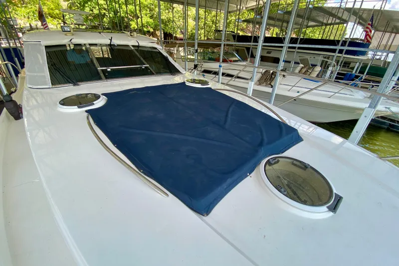 Slide: The Image of 1999 Neptunus 54 Hardtop Express yacht docked, featuring a covered deck and portholes. - 21