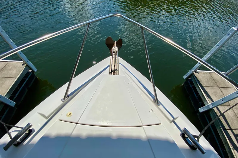 Slide: The Image of Bow view of 1999 Neptunus 54 Hardtop Express yacht docked on calm water. - 22