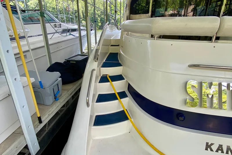 Slide: The Image of 1999 Neptunus 54 Hardtop Express yacht docked with visible steps and equipment. - 24