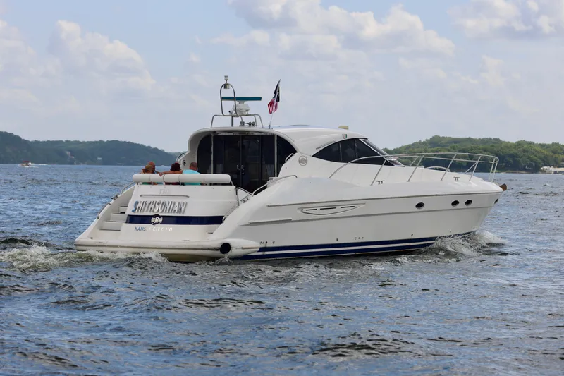 Slide: The Image of 1999 Neptunus 54 Hardtop Express yacht cruising on a scenic lake. - 3