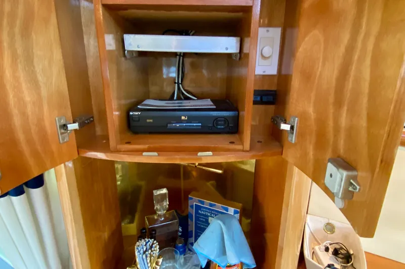 Slide: The Image of 1999 Neptunus 54 Hardtop Express interior cabinet with Sony DVD player and accessories. - 32