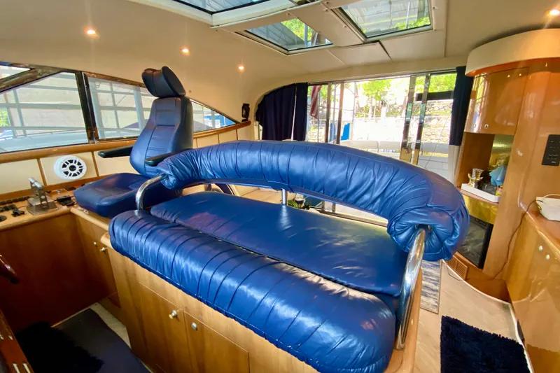 Slide: The Image of Interior of 1999 Neptunus 54 Hardtop Express with blue leather seating and wood accents. - 36