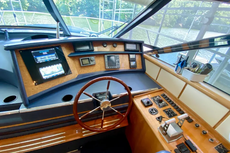 Slide: The Image of Cockpit of 1999 Neptunus 54 Hardtop Express yacht with steering wheel and control panel. - 38