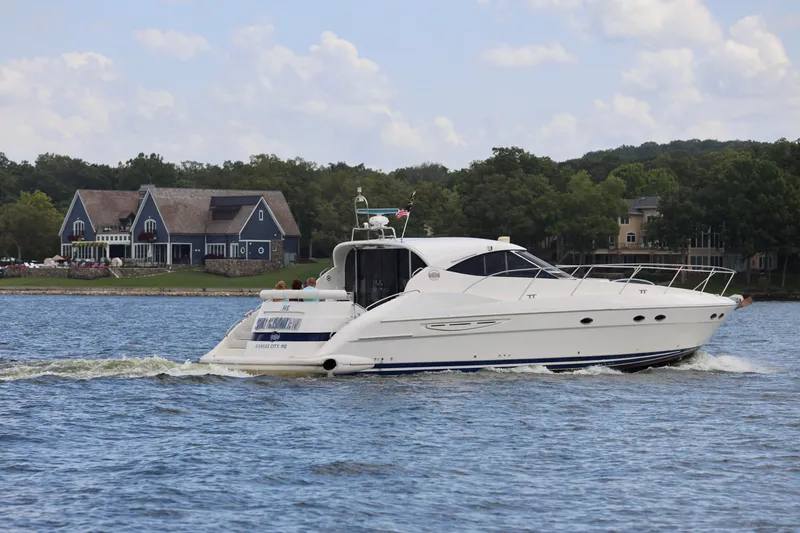 Slide: The Image of 1999 Neptunus 54 Hardtop Express yacht cruising on a scenic lake. - 4