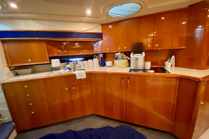 Slide: The Image of Luxurious kitchen interior of 1999 Neptunus 54 Hardtop Express yacht with wooden cabinetry. - 46
