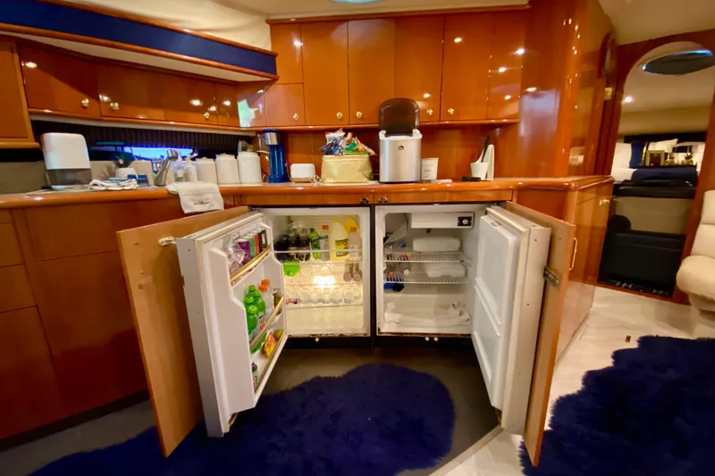 Slide: The Image of Luxurious 1999 Neptunus 54 Hardtop Express yacht kitchen with open fridge and wooden cabinetry. - 47