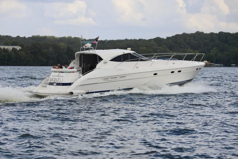 Slide: The Image of 1999 Neptunus 54 Hardtop Express yacht cruising on a scenic lake. - 5