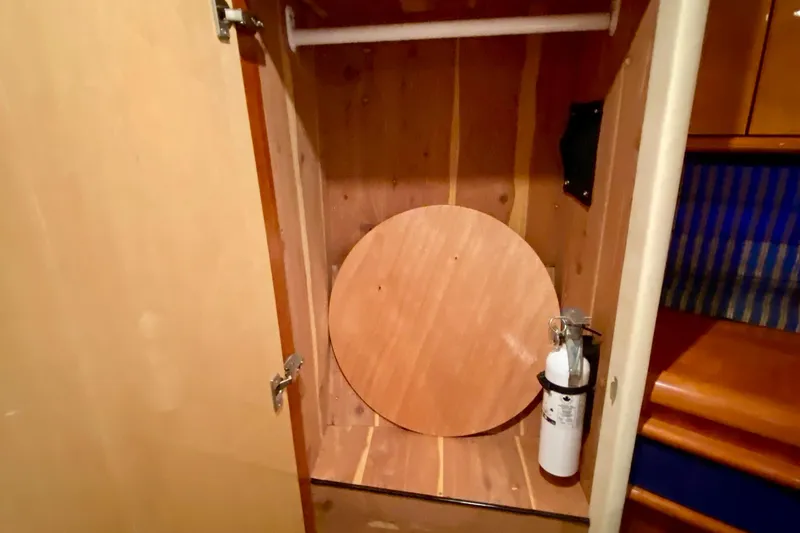 Slide: The Image of Open wooden cabinet on 1999 Neptunus 54 Hardtop Express with fire extinguisher inside. - 52