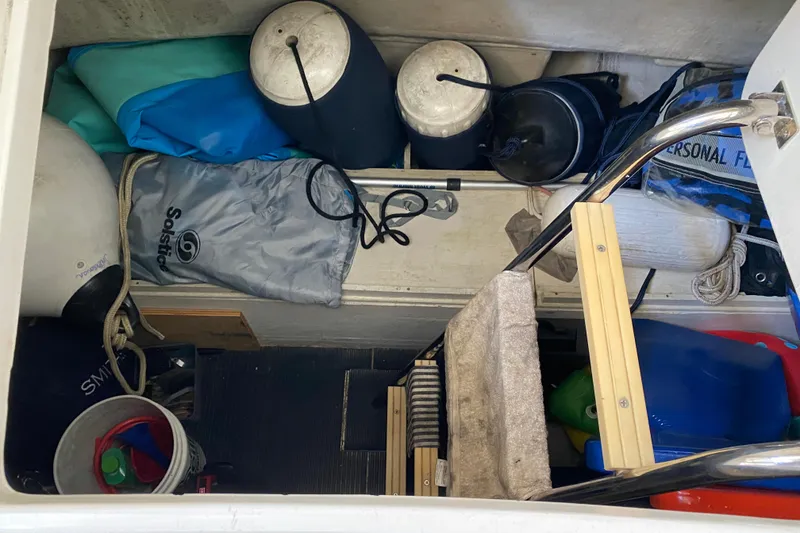 Slide: The Image of Storage compartment of a 1999 Neptunus 54 Hardtop Express with boating equipment and accessories. - 64