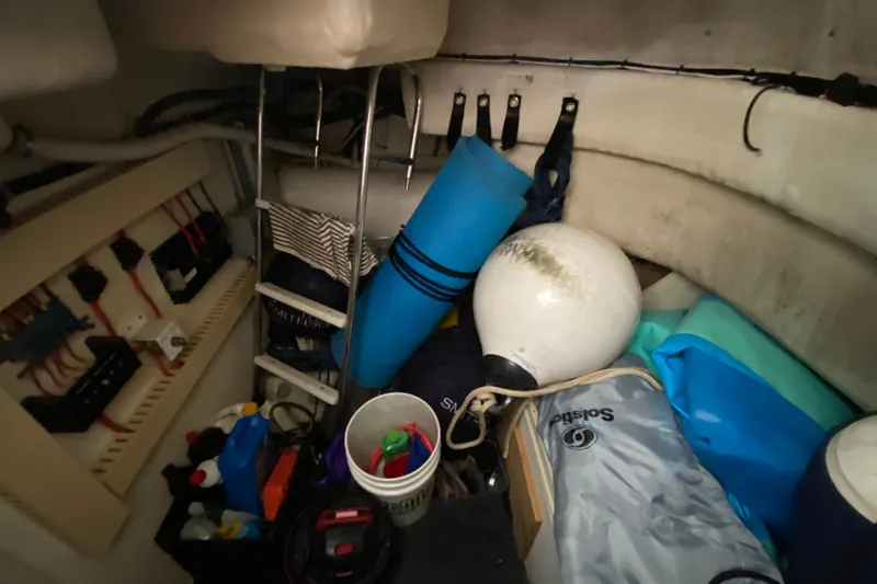 Slide: The Image of Storage area in a 1999 Neptunus 54 Hardtop Express with various boating equipment. - 65