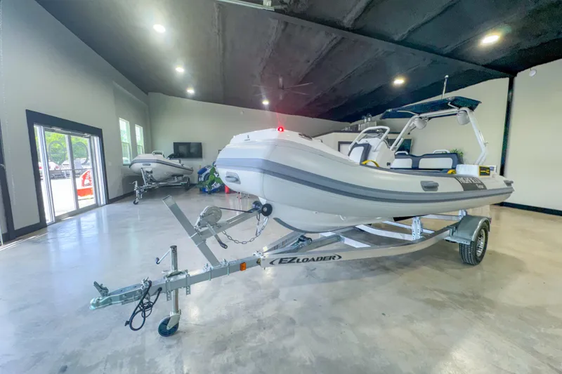 Slide: The Image of 2025 Highfield Velox 420 boat on trailer in showroom, modern design. - 13