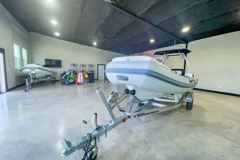 Slide: The Image of 2025 Highfield Velox 420 boat on trailer in spacious indoor showroom. - 4