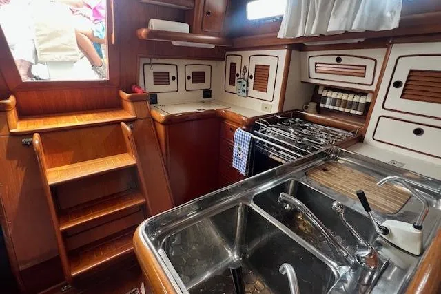 Slide: The Image of 1986 Little Harbor AFt Cockpit K/CB Sloop interior kitchen with wooden cabinetry and stainless steel sink. - 11