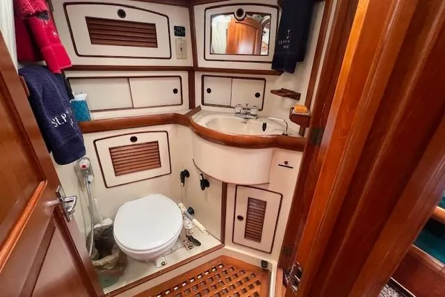 Slide: The Image of 1986 Little Harbor AFt Cockpit K/CB Sloop bathroom with wooden accents and compact design. - 18