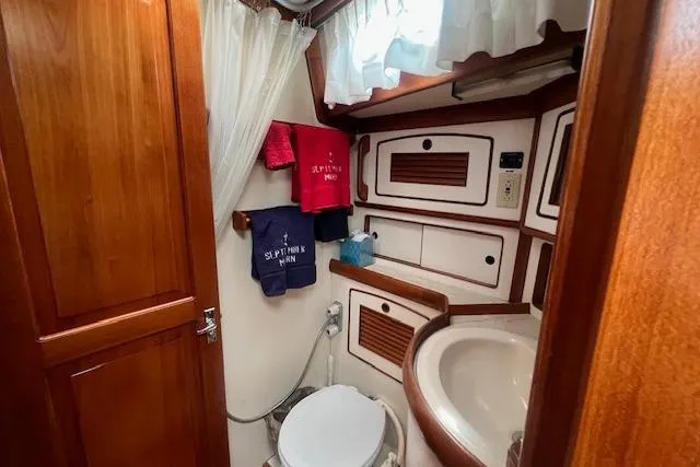 Slide: The Image of 1986 Little Harbor AFt Cockpit K/CB Sloop bathroom with wooden cabinetry and nautical decor. - 19