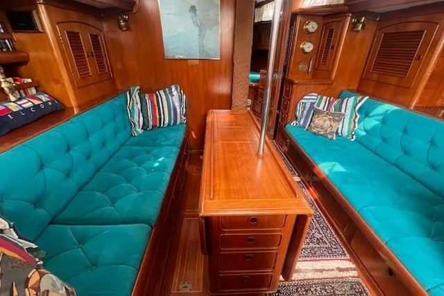 Slide: The Image of Luxurious 1986 Little Harbor AFt Cockpit K/CB Sloop interior with teal seating and wooden cabinetry. - 3