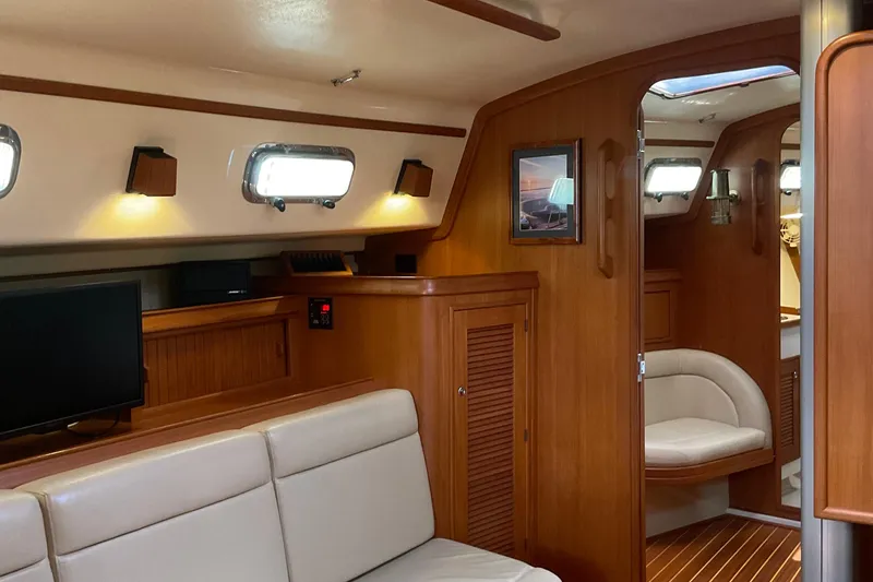 Slide: The Image of Interior of 2001 Island Packet 420 yacht, featuring wood paneling and cozy seating area. - 19