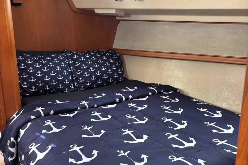 Slide: The Image of Cozy cabin bed with anchor-themed bedding on a 2001 Island Packet 420 sailboat. - 33