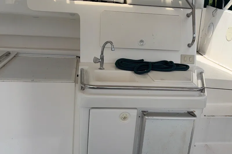 Slide: The Image of 1999 Silverton 392 yacht sink area with coiled rope and storage compartments. - 11